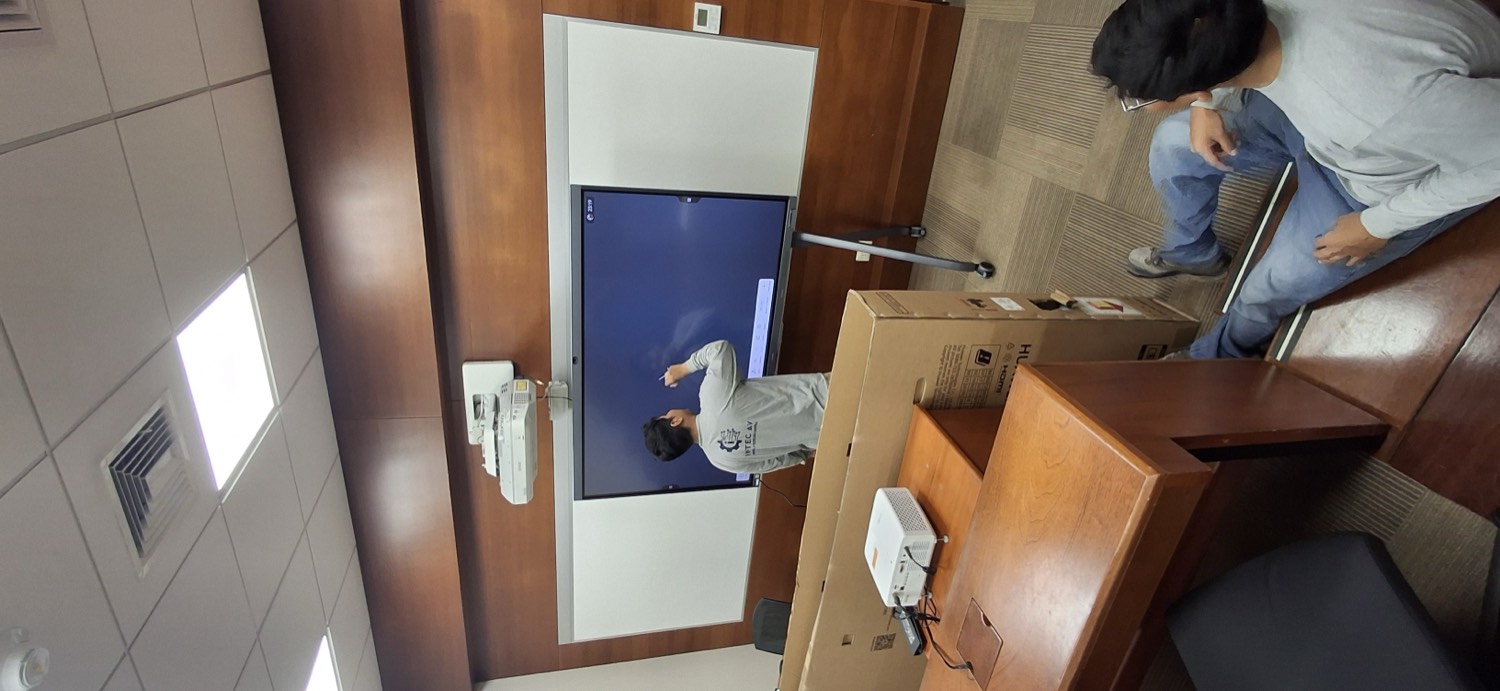 Técnico atendiendo una pantalla instalada en sala